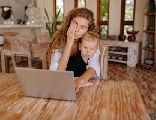 a mother using laptop with her son